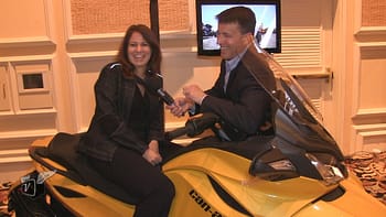 Ken Pyle interviewing Erika Swerdlow on top of a Can-Am motorcycle.