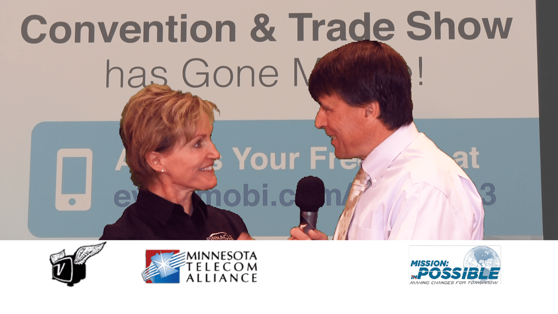 Ken Pyle interviews Lori Otis at the 2013 MTA Convention with the MTA sign as a backdrop.